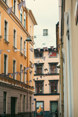 Fototapeta na wymiar Many white flags badges waving in an outdoor street scene in a beautiful old town in Riga