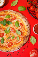 Tasty pizza Margarita with tomatoes and basil on red table