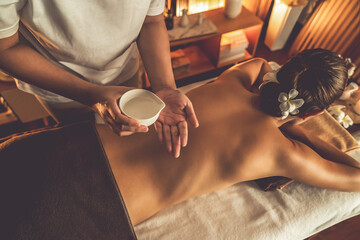 Masseur hands pouring aroma oil on woman back. Masseuse prepare oil massage procedure for customer at spa salon in luxury resort. Aroma oil body massage therapy concept. Quiescent - obrazy, fototapety, plakaty
