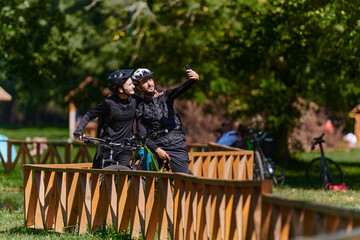 A blissful couple, adorned in professional cycling gear, enjoys a romantic bicycle ride through a...