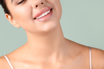 Obraz premium Young woman with beautiful lips on green background, closeup