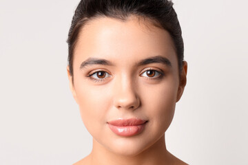 Young woman with beautiful lips on light background, closeup