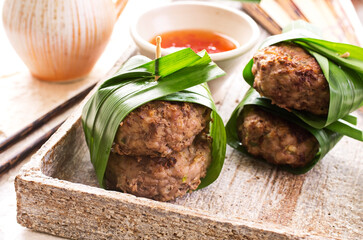 Traditional Thai meatballs with sweet sour chili sauce served as close-up on a design stone tray