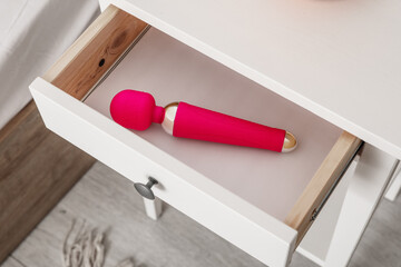 Open drawer with vibrator in bedroom, closeup