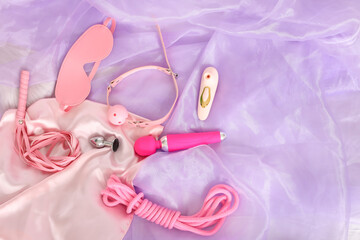 Sex toys on lilac fabric background