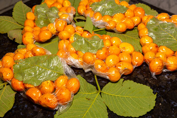 Ripe pequi fruits (Caryocar brasiliense), vacuum packed together with a leaf of the species itself.