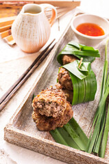 Traditional Thai meatballs with sweet sour chili sauce served as close-up on a design stone tray