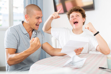 Father congratulates his son after reading a letter from college