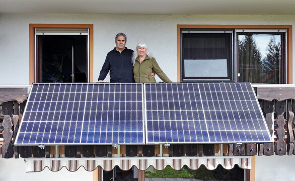 Eine Frau und ihr Mann freuen sich über die neue Solaranlage auf dem Balkon
