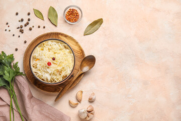 Bowl with delicious sauerkraut and spices on pink background