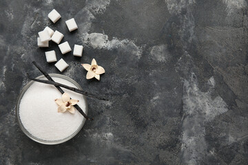 Bowl with aromatic vanilla sugar, flowers and sticks on black background - obrazy, fototapety, plakaty