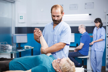 Elderly patient consults specialist assistant, receiving medical help for muscle pain. Nurse...