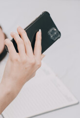 Efficient Young Millennial Girl Sitting on a Bed in the Morning, Uses Laptop Computer and Eats Croissants and Drinks Coffee for Breakfast