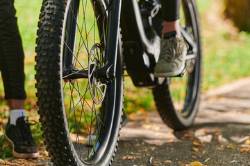 Naklejka premium A sports bicycle races through the park, its components in focused motion spinning wheels, agile pedals, and sleek handlebars creating a dynamic spectacle of athleticism and speed against the backdrop