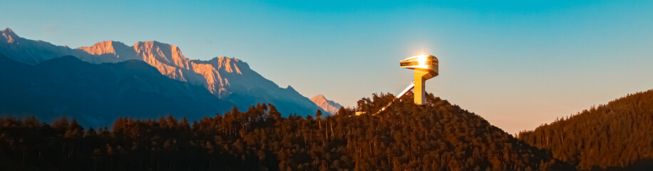 Alpine sunset or sundowner with the famous Berg Isel ski jump facility and the Nordkette mountains...