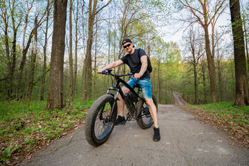 Man on a fatbike in the woods. Pleasant sports hobby. Concept of a healthy lifestyle.