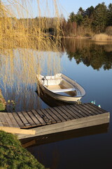 boat on the lake next to old, wooden pier