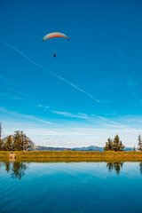 Alpine summer view with reflections and a paraglider at Lake Spiegelsee, Mount Fulseck,...
