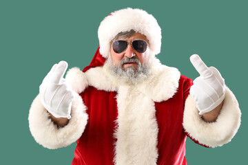 Bad Santa Claus showing middle fingers on green background