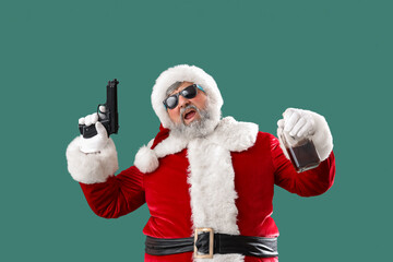 Bad Santa Claus with gun and drink on green background
