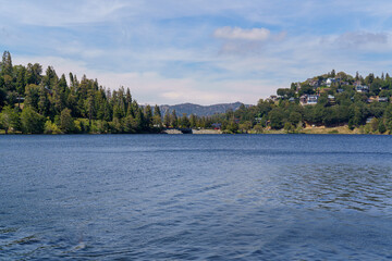Fototapeta na wymiar View of the water, shoreline, and mountains at Lake Gregory Regional Park in Crestline, California