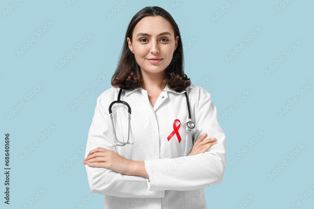 Poster female doctor with red ribbon on blue background. world aids day concept