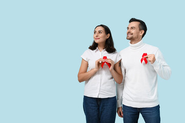 Lovely couple with red ribbons on blue background. World AIDS Day concept