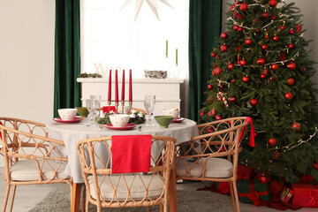 Interior of festive room with Christmas tree, decorations and served dining table