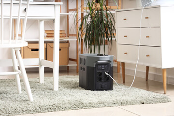Portable power station with charging phone on floor in contemporary room