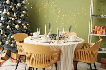 Festive table setting with Christmas decorations, reindeers and burning candles in dining room
