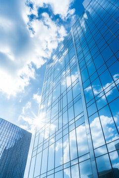 Reflective skyscrapers, business office buildings. Low angle photography of glass curtain wall details of high-rise buildings.The window glass reflects the blue sky and white clouds. High quality
