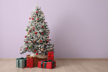 Presents under beautiful Christmas tree against color wall