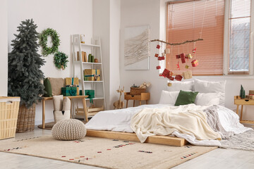 Interior of festive bedroom with Christmas decorations and hanging gift boxes