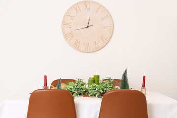 Festive table serving with mistletoe wreath, burning candles and Christmas decorations