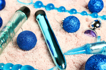 Sex toys with Christmas decor on beige fluffy carpet