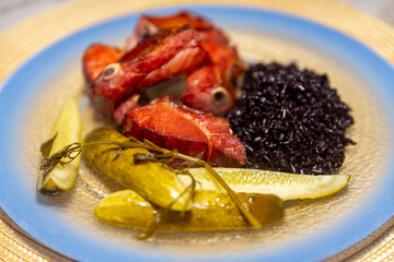 Traditional rustic Brazilian food, black rice, smoked pork ribs and pickles