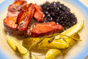 Traditional rustic Brazilian food, black rice, smoked pork ribs and pickles