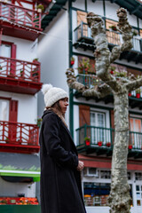 Amid colorful bokeh, a young Caucasian tourist enjoys Hondarribia's vibrant charm.