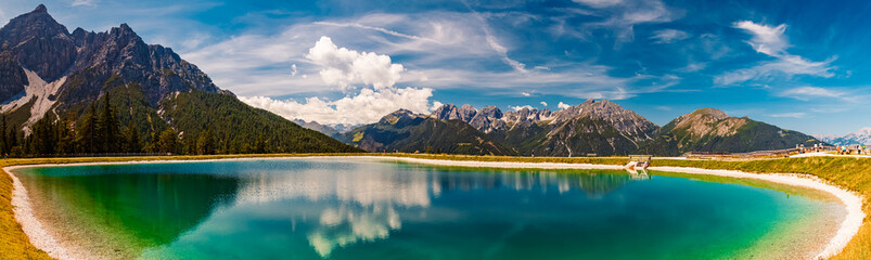 High resolution stitched alpine summer panorama with reflections in a lake at Serles cable car...