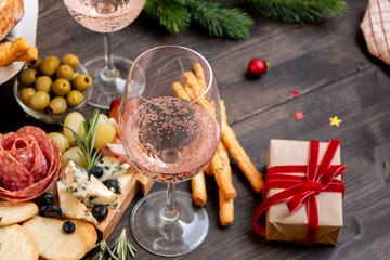 festive aperitif or party two glasses of champagne, Prosecco or rosé wine with cold meat appetizers cheeses and olives