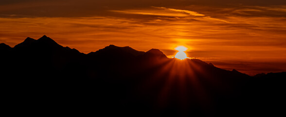 Alpine sunset or sundowner with sunstar effect at Mount Stubnerkogl, Bad Gastein, St. Johann im Pongau, Salzburg, Austria