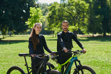 Obraz premium A blissful couple, adorned in professional cycling gear, enjoys a romantic bicycle ride through a park, surrounded by modern natural attractions, radiating love and happiness