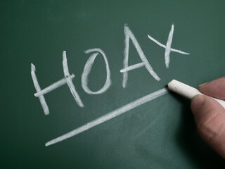 Hoax, text written on chalkboard, fake news gossip issue