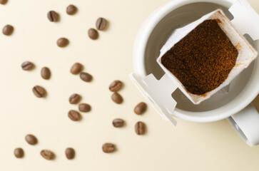 Drip coffee bag in a cup on a yellow background. A quick way to prepare a tasty and aromatic drink. Horizontal orientation. Top view. Copy space