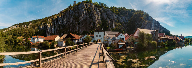 High resolution stitched summer panorama with reflections, a bridge, a church and an ancient...