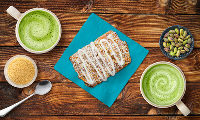 Pastry to share and matcha latte on bright napkin with nuts on table top at a cafe