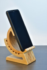 Cell phone adjustable angle wood base. Tabletop wooden smart phone holder. Desk cell phone stand made of plywood.
