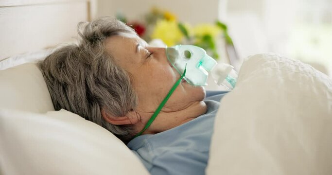 Sick, woman and oxygen for breathing in a hospital bed, health problem or in a coma. Medicine, sleeping and a senior patient with a mask to breathe for medical help, lungs or ventilation at a clinic