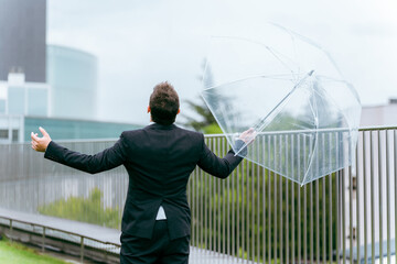 雨の日に傘をさす外国人ビジネスマン（梅雨・台風・雨上がり・異常気象）
 - obrazy, fototapety, plakaty