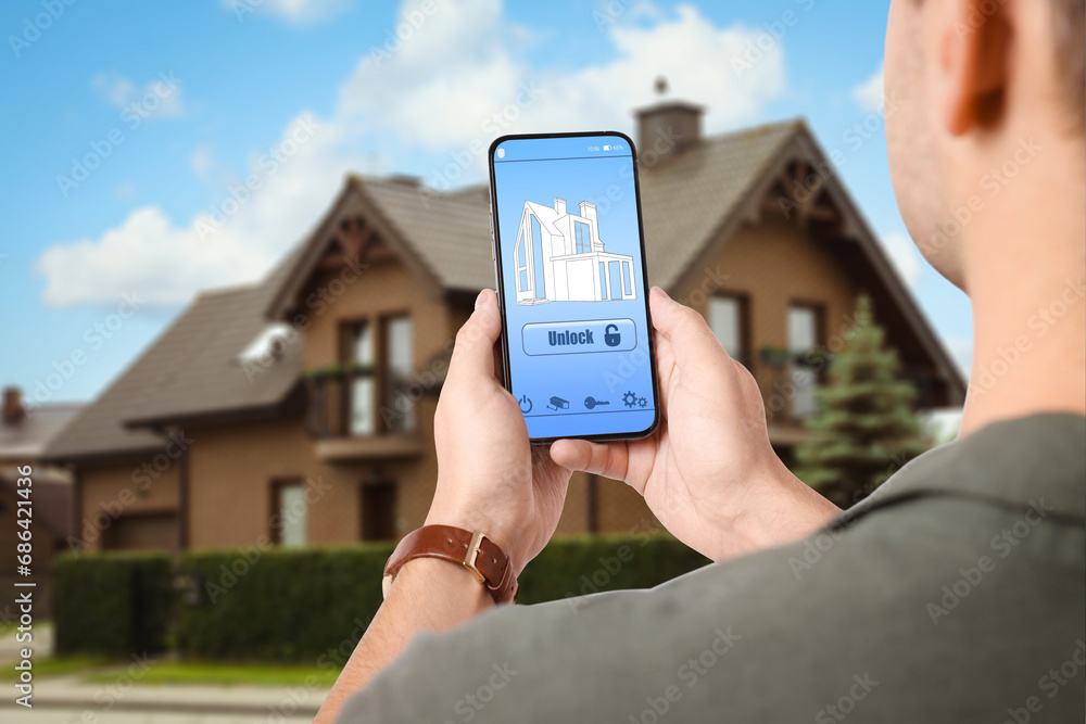 Poster man using home security system application on smartphone outdoors, closeup